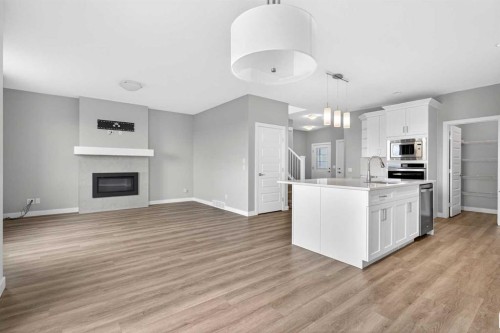 181 Buckskin Way, Cochrane, AB - Indoor Photo Showing Kitchen With Fireplace With Upgraded Kitchen