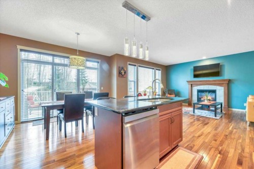 8 Sunset Square, Cochrane, AB - Indoor Photo Showing Kitchen With Fireplace