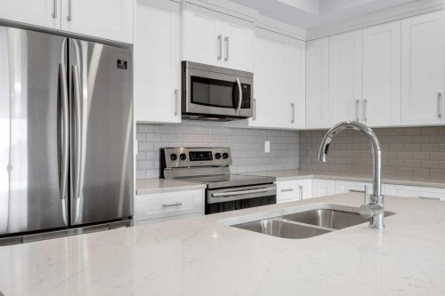 323-4150 Seton Drive Se, Calgary, AB - Indoor Photo Showing Kitchen With Stainless Steel Kitchen With Double Sink With Upgraded Kitchen