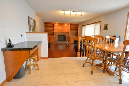 393 Hawktree Circle Nw, Calgary, AB - Indoor Photo Showing Dining Room With Fireplace