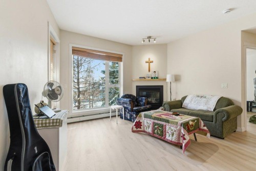 210-69 Springborough Court Sw, Calgary, AB - Indoor Photo Showing Living Room With Fireplace