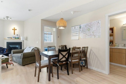 210-69 Springborough Court Sw, Calgary, AB - Indoor Photo Showing Dining Room With Fireplace