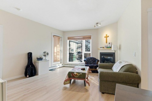 210-69 Springborough Court Sw, Calgary, AB - Indoor Photo Showing Living Room With Fireplace