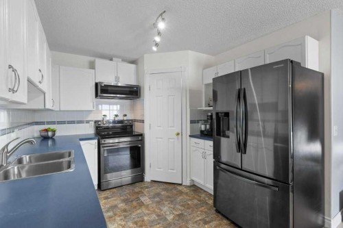 202 Willowbrook Close Nw, Airdrie, AB - Indoor Photo Showing Kitchen With Double Sink