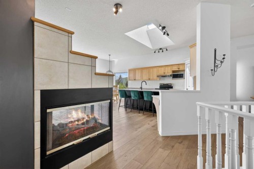 18 Eagleview Place, Cochrane, AB - Indoor Photo Showing Kitchen With Fireplace