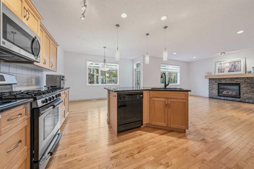 109 Silverado Creek Crescent Sw, Calgary, AB - Indoor Photo Showing Kitchen With Fireplace With Upgraded Kitchen