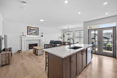 224 Precedence Hill, Cochrane, AB - Indoor Photo Showing Kitchen With Fireplace