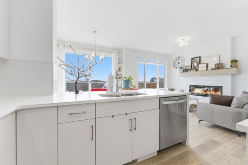 936 Langholm Drive Se, Airdrie, AB - Indoor Photo Showing Kitchen With Fireplace With Double Sink