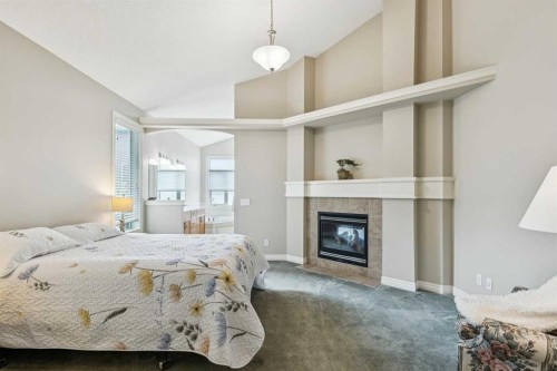94 Panatella Close Nw, Calgary, AB - Indoor Photo Showing Bedroom With Fireplace