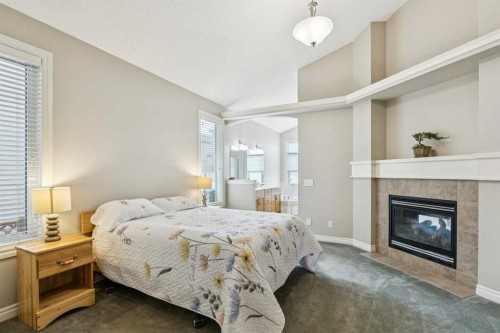 94 Panatella Close Nw, Calgary, AB - Indoor Photo Showing Bedroom With Fireplace