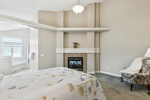 94 Panatella Close Nw, Calgary, AB - Indoor Photo Showing Bedroom With Fireplace