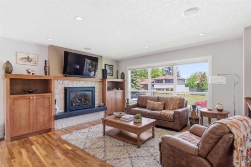 351 Queen Charlotte Road Se, Calgary, AB - Indoor Photo Showing Living Room With Fireplace