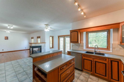 117 Evergreen Place Sw, Calgary, AB - Indoor Photo Showing Kitchen With Fireplace With Double Sink