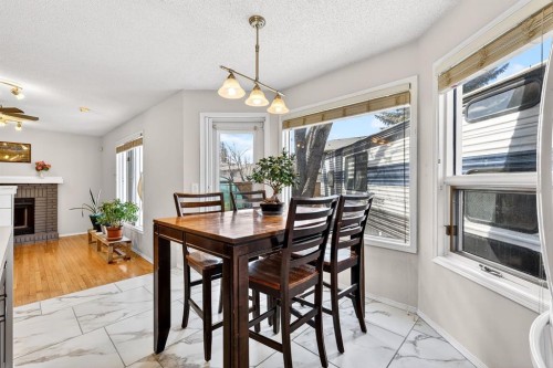 29 Sundown Way Se, Calgary, AB - Indoor Photo Showing Dining Room With Fireplace