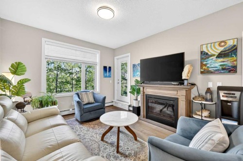 216-35 Aspenmont Heights Sw, Calgary, AB - Indoor Photo Showing Living Room With Fireplace