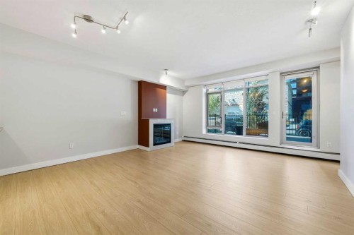 103-733 2 Avenue Sw, Calgary, AB - Indoor Photo Showing Living Room With Fireplace