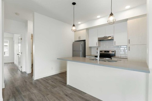 401-24 Rivercrest Drive, Cochrane, AB - Indoor Photo Showing Kitchen With Double Sink With Upgraded Kitchen