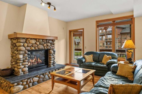 202-505 Spring Creek Drive, Canmore, AB - Indoor Photo Showing Living Room With Fireplace