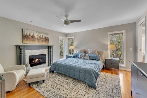 28 Woodacres Way Sw, Calgary, AB - Indoor Photo Showing Bedroom With Fireplace