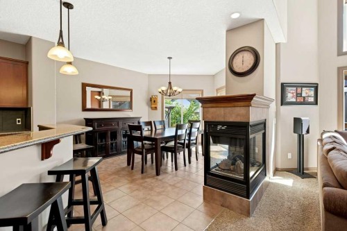 23 Aspen Stone Crescent Sw, Calgary, AB - Indoor Photo Showing Dining Room With Fireplace
