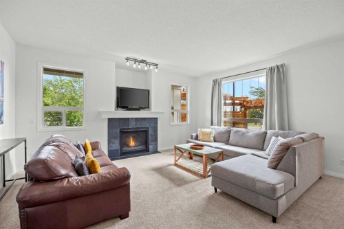 318 Coopers Drive Sw, Airdrie, AB - Indoor Photo Showing Living Room With Fireplace
