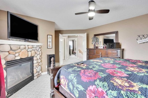 251 Lakeview Cove, Chestermere, AB - Indoor Photo Showing Bedroom With Fireplace