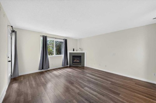 202-6148 Bowness Road Nw, Calgary, AB - Indoor Photo Showing Living Room With Fireplace