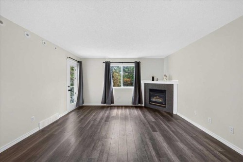 202-6148 Bowness Road Nw, Calgary, AB - Indoor Photo Showing Living Room With Fireplace