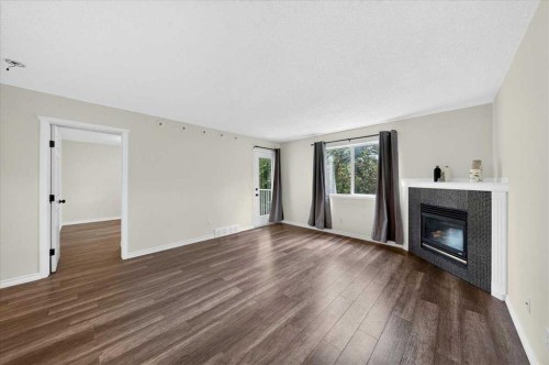 202-6148 Bowness Road Nw, Calgary, AB - Indoor Photo Showing Living Room With Fireplace