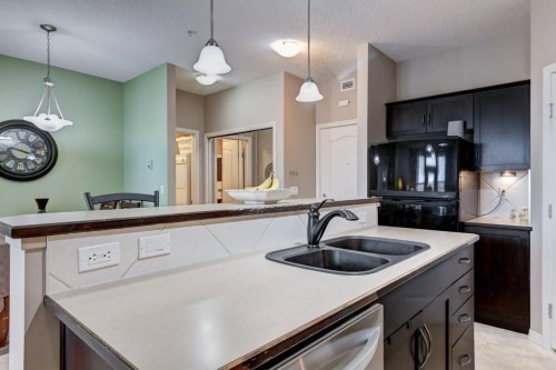 123-1 Crystal Green, Okotoks, AB - Indoor Photo Showing Kitchen With Double Sink