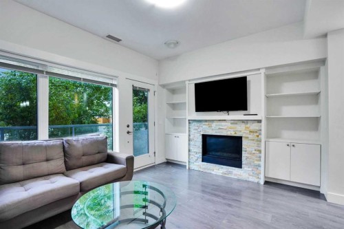 207-20 Brentwood Common Nw, Calgary, AB - Indoor Photo Showing Living Room With Fireplace