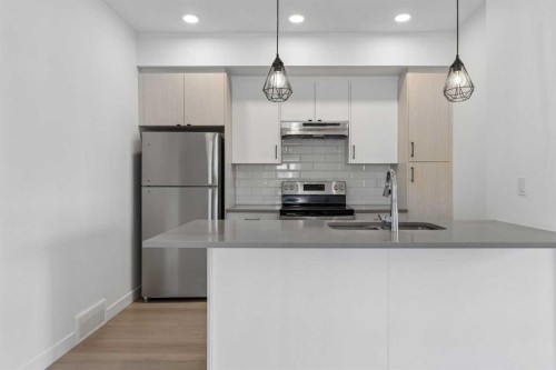 1001-24 Rivercrest Drive, Cochrane, AB - Indoor Photo Showing Kitchen With Stainless Steel Kitchen With Upgraded Kitchen