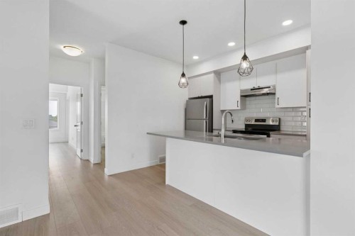 1001-24 Rivercrest Drive, Cochrane, AB - Indoor Photo Showing Kitchen With Stainless Steel Kitchen With Double Sink With Upgraded Kitchen