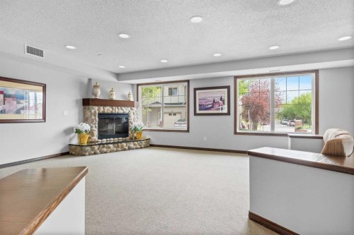 220-8 Prestwick Pond Terrace Se, Calgary, AB - Indoor Photo Showing Living Room With Fireplace