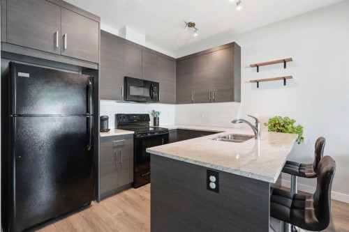 204 Jumping Pound Common, Cochrane, AB - Indoor Photo Showing Kitchen With Double Sink
