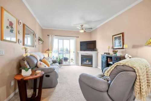 302-15 Lineham Avenue, Okotoks, AB - Indoor Photo Showing Living Room With Fireplace