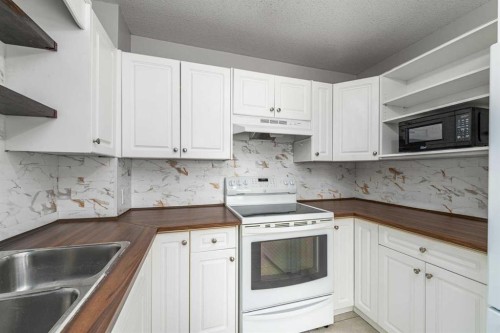 1-12 Silver Creek Boulevard Nw, Airdrie, AB - Indoor Photo Showing Kitchen With Double Sink