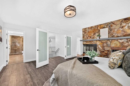 884 East Chestermere Drive, Chestermere, AB - Indoor Photo Showing Bedroom With Fireplace