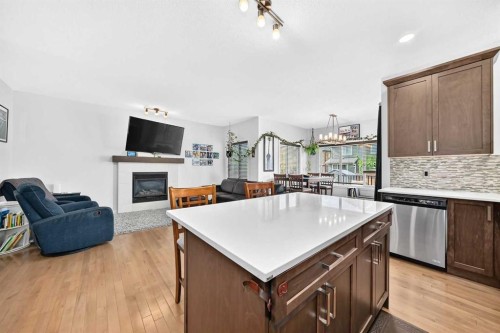16 Sunrise Crescent, Cochrane, AB - Indoor Photo Showing Kitchen With Fireplace