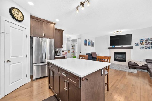 16 Sunrise Crescent, Cochrane, AB - Indoor Photo Showing Kitchen With Fireplace