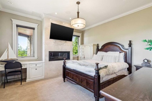 39 Red Willow Crescent West, Rural Foothills County, AB - Indoor Photo Showing Bedroom With Fireplace