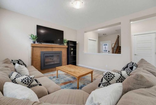 145 Sunset Manor, Cochrane, AB - Indoor Photo Showing Living Room With Fireplace