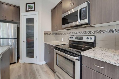 145 Sunset Manor, Cochrane, AB - Indoor Photo Showing Kitchen With Stainless Steel Kitchen With Upgraded Kitchen