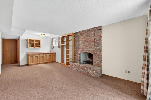 212 Stravanan Bay Sw, Calgary, AB - Indoor With Fireplace