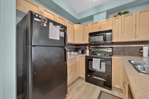 2103-211 Aspen Stone Boulevard Sw, Calgary, AB - Indoor Photo Showing Kitchen With Double Sink