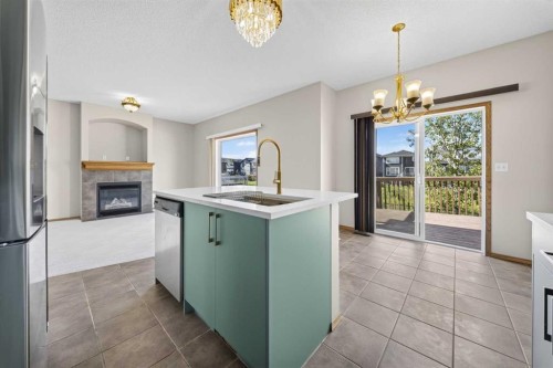 744 Luxstone Landing Sw, Airdrie, AB - Indoor Photo Showing Kitchen With Fireplace