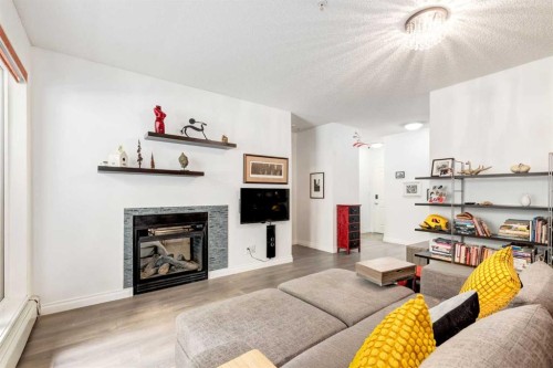 101-532 5 Avenue Ne, Calgary, AB - Indoor Photo Showing Living Room With Fireplace