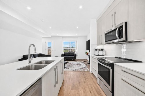 308-135 Belmont Passage Sw, Calgary, AB - Indoor Photo Showing Kitchen With Stainless Steel Kitchen With Double Sink With Upgraded Kitchen