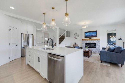 136 Sunrise Common, Cochrane, AB - Indoor Photo Showing Kitchen With Fireplace With Double Sink With Upgraded Kitchen