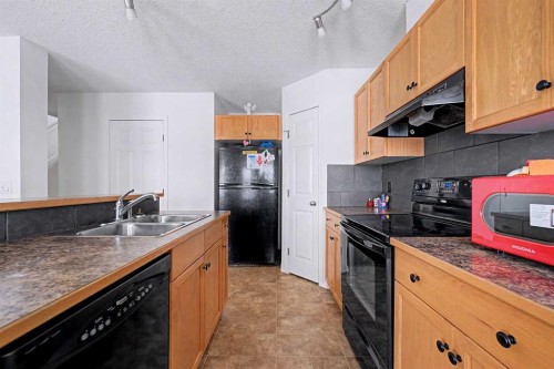 102-800 Yankee Valley Boulevard Se, Airdrie, AB - Indoor Photo Showing Kitchen With Double Sink